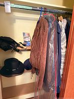 Jackets hanging on rack with hats on shelf