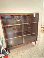 Front view showing glass sliding doors and interior shelves