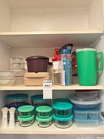 Cabinet shelves showing majority of containers, pitcher, bottle, shakers