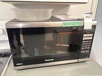 Front view of Panasonic stainless steel and black countertop microwave with control panel and tray on top