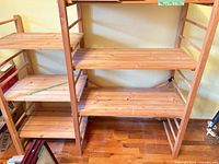 Front view of pine shelving unit showing six slatted shelves and natural finish