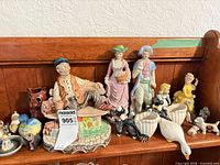 Full shelf view showing all ceramic figurines and items in lot