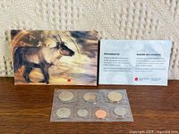 Front view showing caribou envelope, information card and sealed 7-coin strip