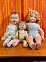 Front view of the three composition baby dolls seated together