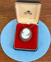 Front view of cameo pendant brooch in box