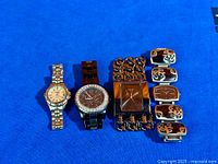 All three Guess watches and six logo panels on blue background