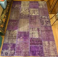 Full view of purple patchwork rug on hardwood floor