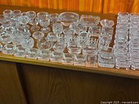 overview of large group of clear glass open salts on table