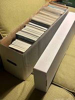 Closed long box and separate white box lid showing quantity of comics