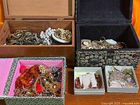 Overview of four open jewelry boxes filled with assorted vintage jewelry pieces