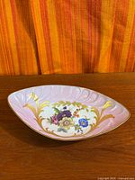 Overall view of triangular Limoges porcelain floral dish on wood surface