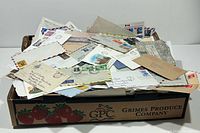 Cardboard crate filled with numerous stamped envelopes and First Day Covers