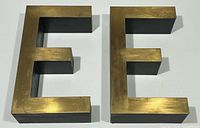 Front view of both brass letters E showing brass faces