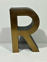 Front view showing brass face and letter shape