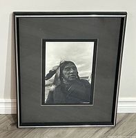 Full view of framed photograph on floor against wall