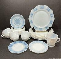 Group view of dinnerware pieces showing dinner plates, side plates, saucers, cups, sugar bowl