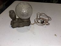 Full view of lamp showing owl base, frosted globe and cloth cord
