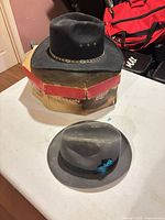Black and gray felt hats on table with Stetson box