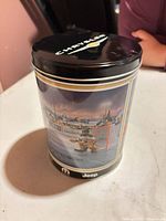 Tin standing upright showing lid with Chrysler wordmark and wing emblem