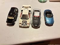 Four diecast cars lined up front view