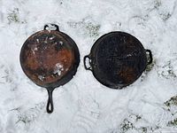 Both cast iron pieces displayed on snow: skillet left, lid right
