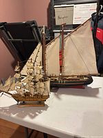 Both wooden model sailboats side by side