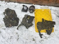 All items laid out on snow: three vests/harnesses, two masks, pod tube