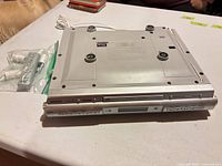 Bottom view of Sony ICF-CDX50 unit showing attached cord and mounting points