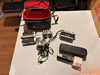 Overview of all items laid out with shoulder case, cameras, flash units, mounts, pouches