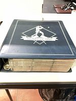 Closed blue Baseball Card Album showing thickness of filled pages