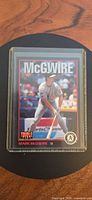 Front of card in top loader, McGwire batting