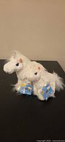 Both unicorn plush toys side-by-side showing size difference and tags