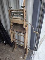 Full view of washing machine on stand showing rollers, crank and base