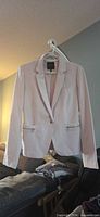 Front view of soft pink blazer on hanger