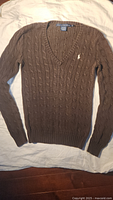 Full front view of brown cable-knit sweater