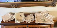 Three stacks of folded antique handkerchiefs and a crocheted doily on dresser top