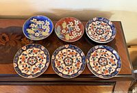 Seven Imari porcelain pieces displayed on sideboard