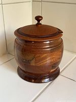 Front view of wooden tobacco pot showing segmented pattern and lid