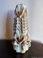 Full front view of carved ivory and brown pillar candle