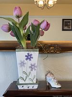 Vase with tulips and shoe pin cushion on tabletop