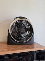 Front view of Honeywell black table fan on wooden surface