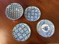 Top view of all four porcelain pieces showing patterns and gold rims