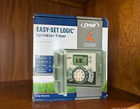 Front of retail box displaying Orbit Easy-Set Logic 4 Station Sprinkler Timer image and features