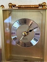 Front of brass-tone carriage mantel clock showing dial