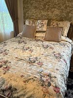 Bed with floral comforter, shams and accent pillows