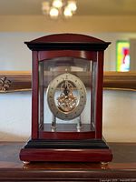 Full front view of clock showing wooden case and glass panels
