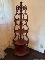 Full view of tall carved corner etagere showing all four shelves and decorative crest