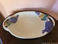 Top view of oval basketweave platter with grape clusters and leaves