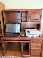 Front view showing desk base, hutch, drawers, keyboard tray, shelves, cabinet