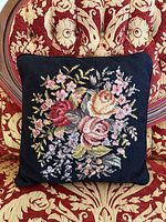 Front of pillow showing needlepoint floral design